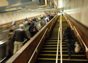 Many people are riding the escalators but only one person is taking the stairs